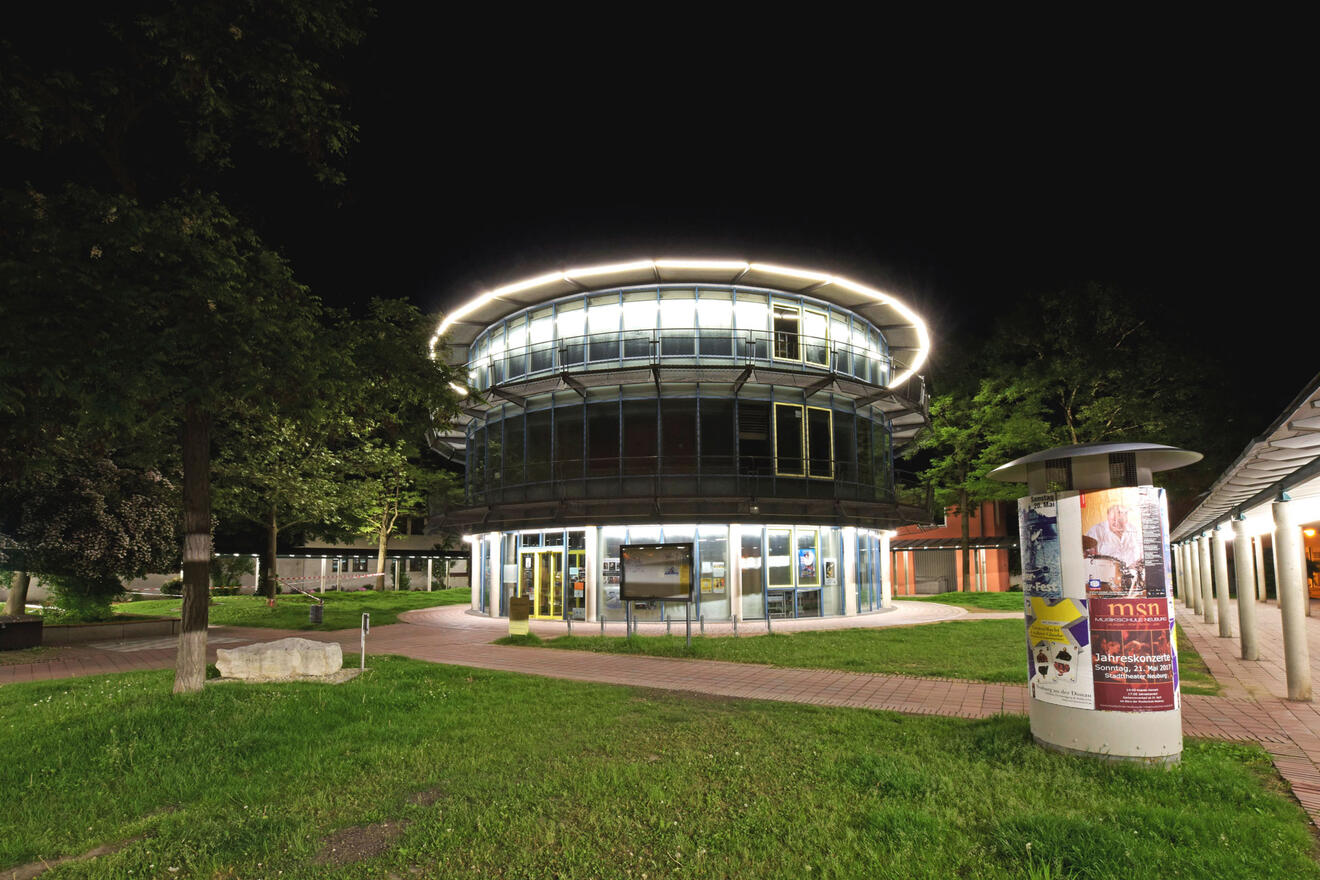 Der Bücherturm am Sèter Platz nachts beleuchtet.